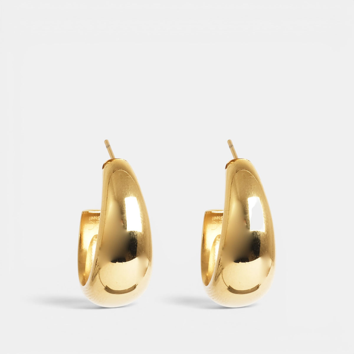 A & C Oslo PURE STEEL SOFT gold earring with a smooth, rounded design and polished finish, displayed against a neutral background.