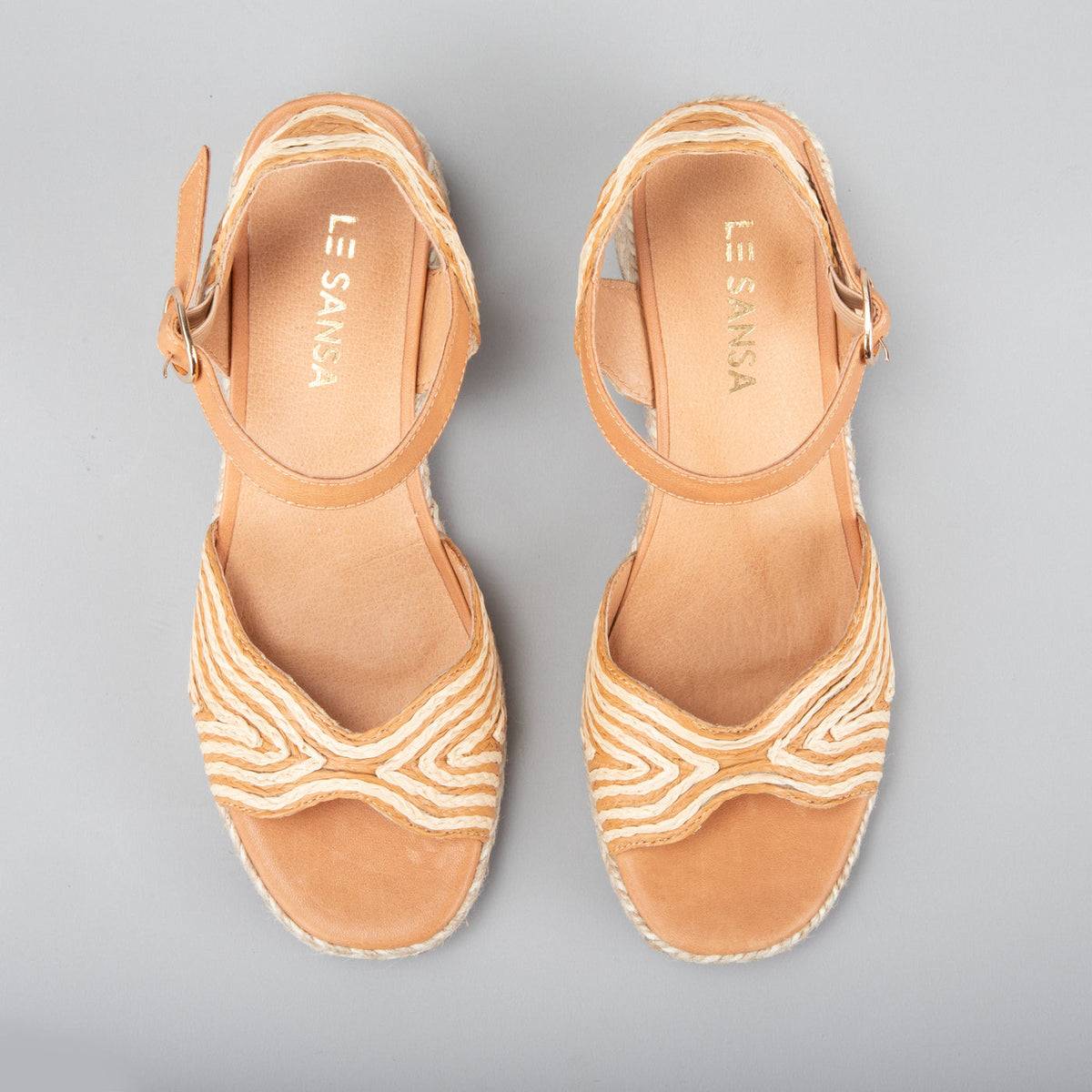 Le Sansa Alys tan and beige sandals with open toes and ankle straps, featuring a stylish and comfortable design.