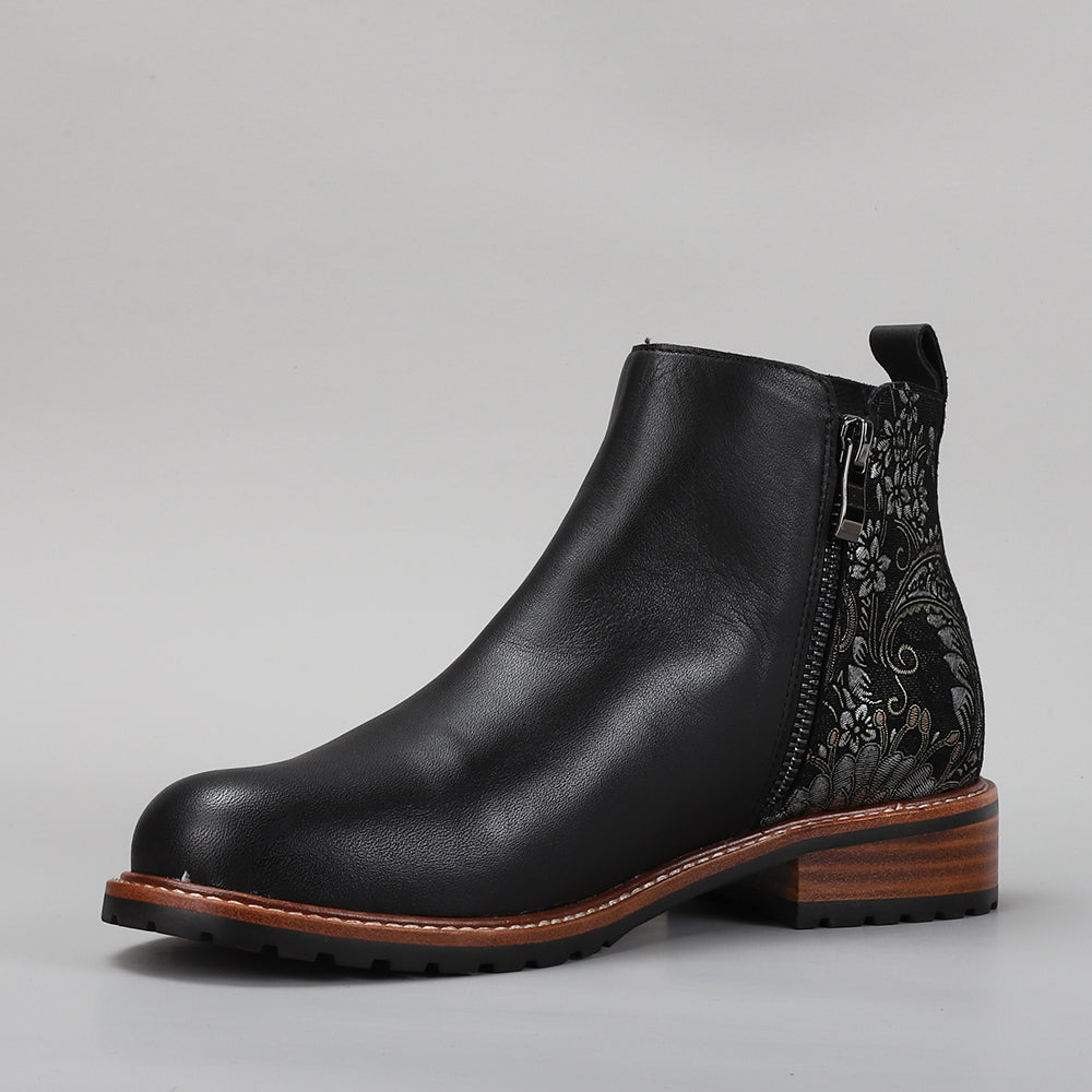 Black leather boots with printed fig design by Le Sansa, showcasing stylish footwear with artistic detailing.