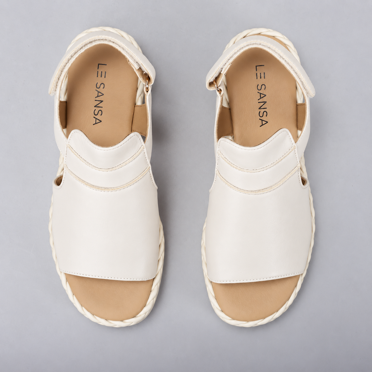 Le Sansa Emmeline Cream sandals featuring beige straps and a comfortable flat sole, perfect for casual summer wear.