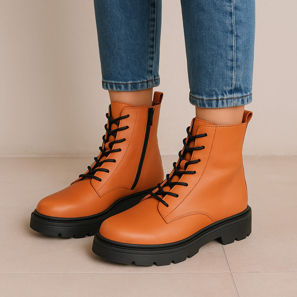 Le Sansa Radiant Orange boots featuring a vibrant orange leather design with sleek style and sturdy sole.