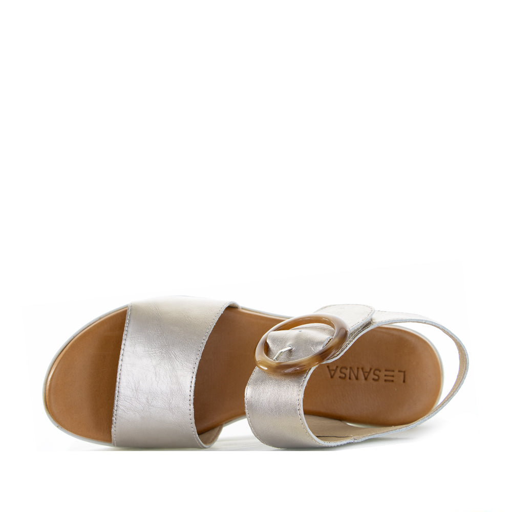 Le Sansa Guard Champagne sandals featuring a sleek design with champagne-colored straps and a comfortable flat sole.