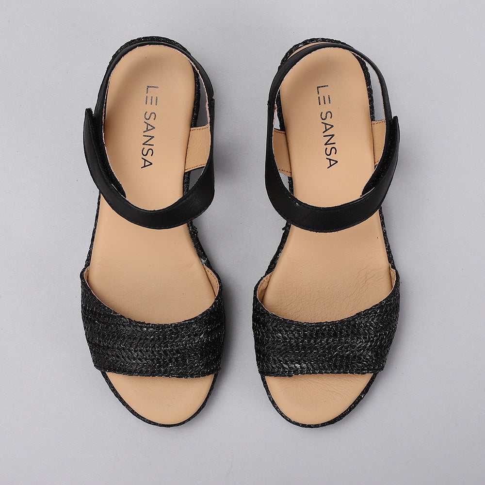 Black Le Sansa Sansa Pilia sandals with open-toe design and ankle straps, displayed on a neutral background.
