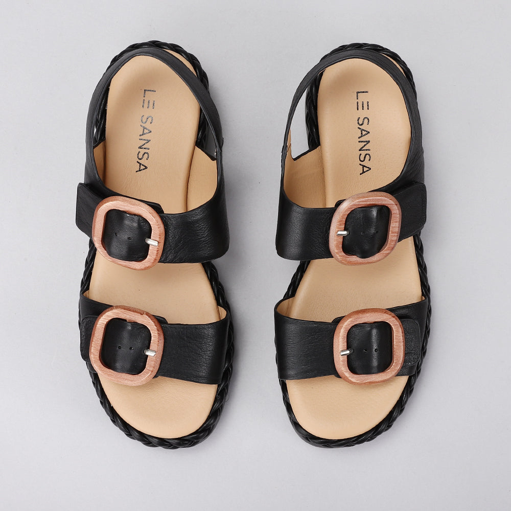 Black leather sandals from Le Sansa Sansa Emery collection, featuring a stylish open-toe design and ankle strap.