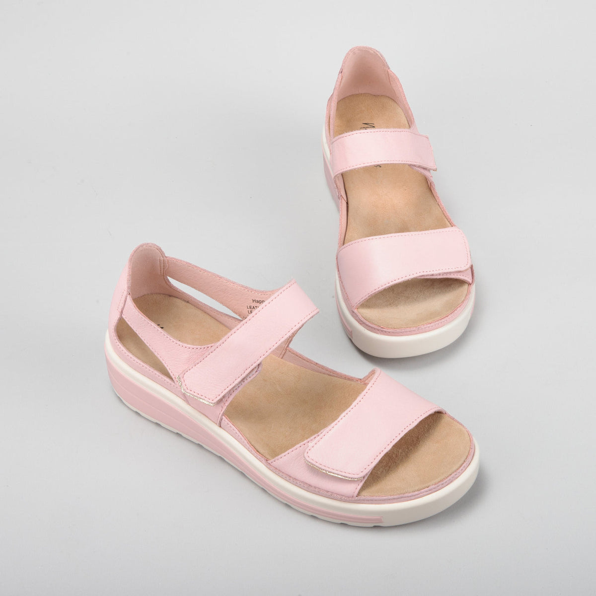 Naked Arches Happy Baby Pink sandals for infants with soft pink straps and cushioned sole, designed for comfort and style.