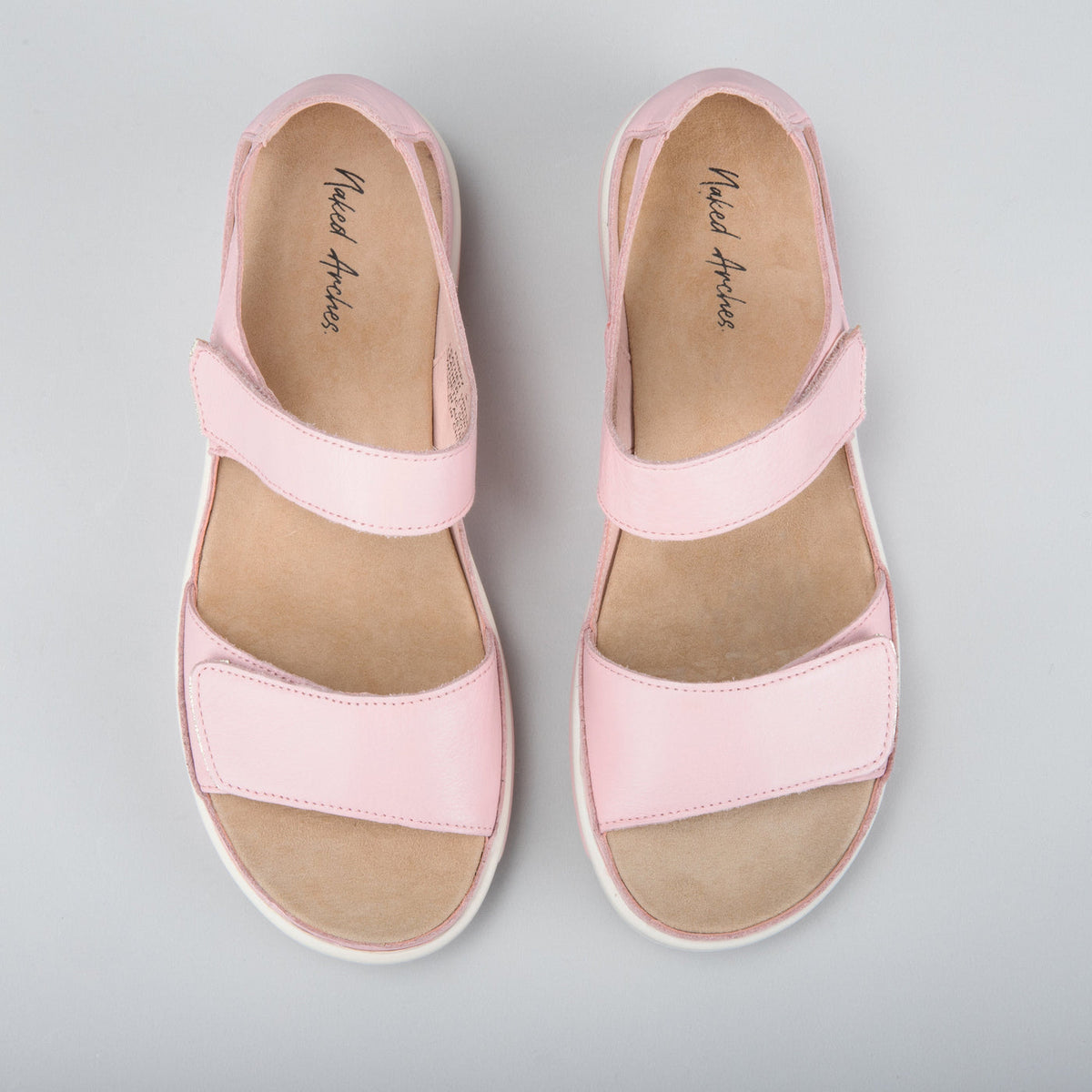 Naked Arches Happy Baby Pink sandals for infants, featuring soft pink straps and comfortable barefoot design.