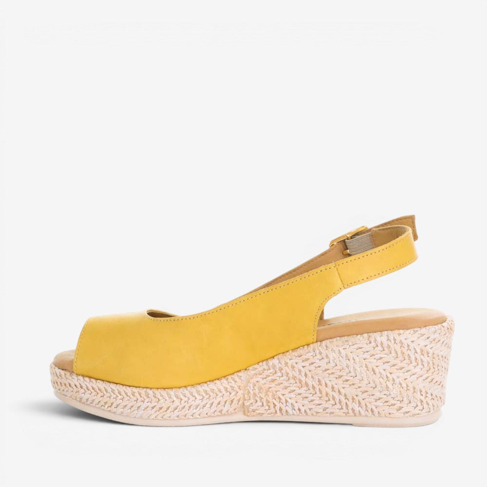 Le Sansa Petunia Mustard sandals featuring open-toe design and strappy details, perfect for summer wear.