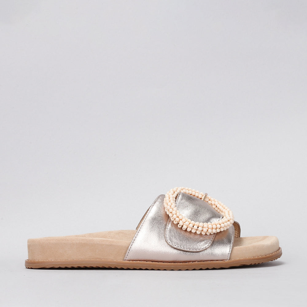 Naked Arches Zoya Champagne slip-on shoes with a sleek design and metallic finish, shown on a neutral background.