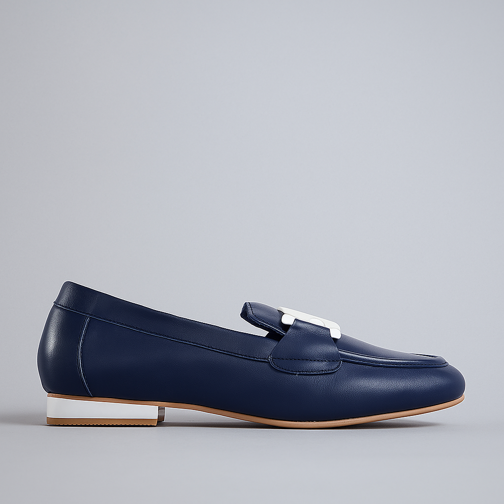 Naked Arches navy and white loafers displayed on a stand, showcasing the stylish design and color contrast of the footwear.