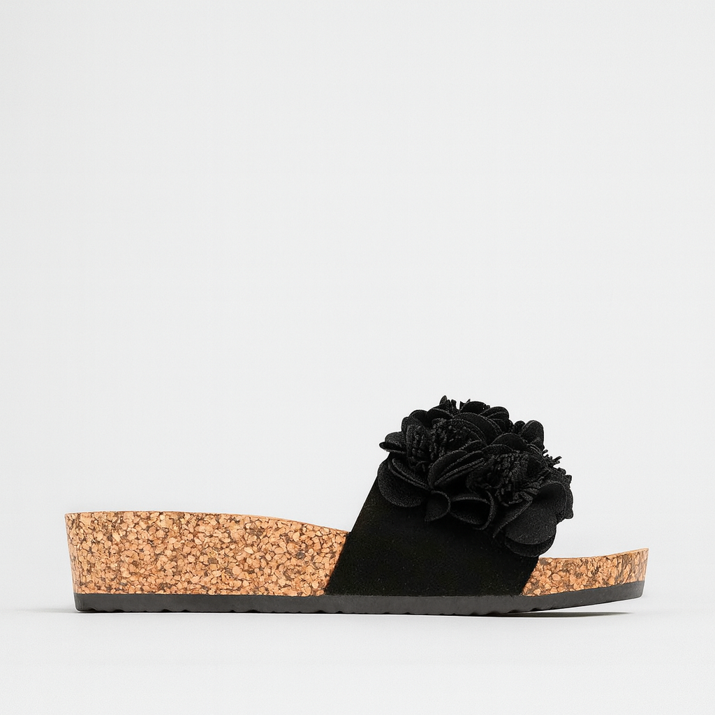 Black LOS CABOS slippers with a sleek design, shown on display, featuring comfortable slip-on style and casual footwear look.