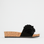 Black LOS CABOS slippers with a sleek design, shown on display, featuring comfortable slip-on style and casual footwear look.