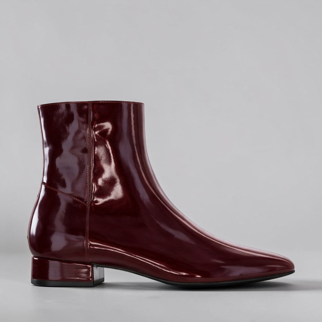 Le Sansa Sasha Merlot Patent Boots in glossy burgundy with a sleek, shiny finish and stylish ankle-high design.