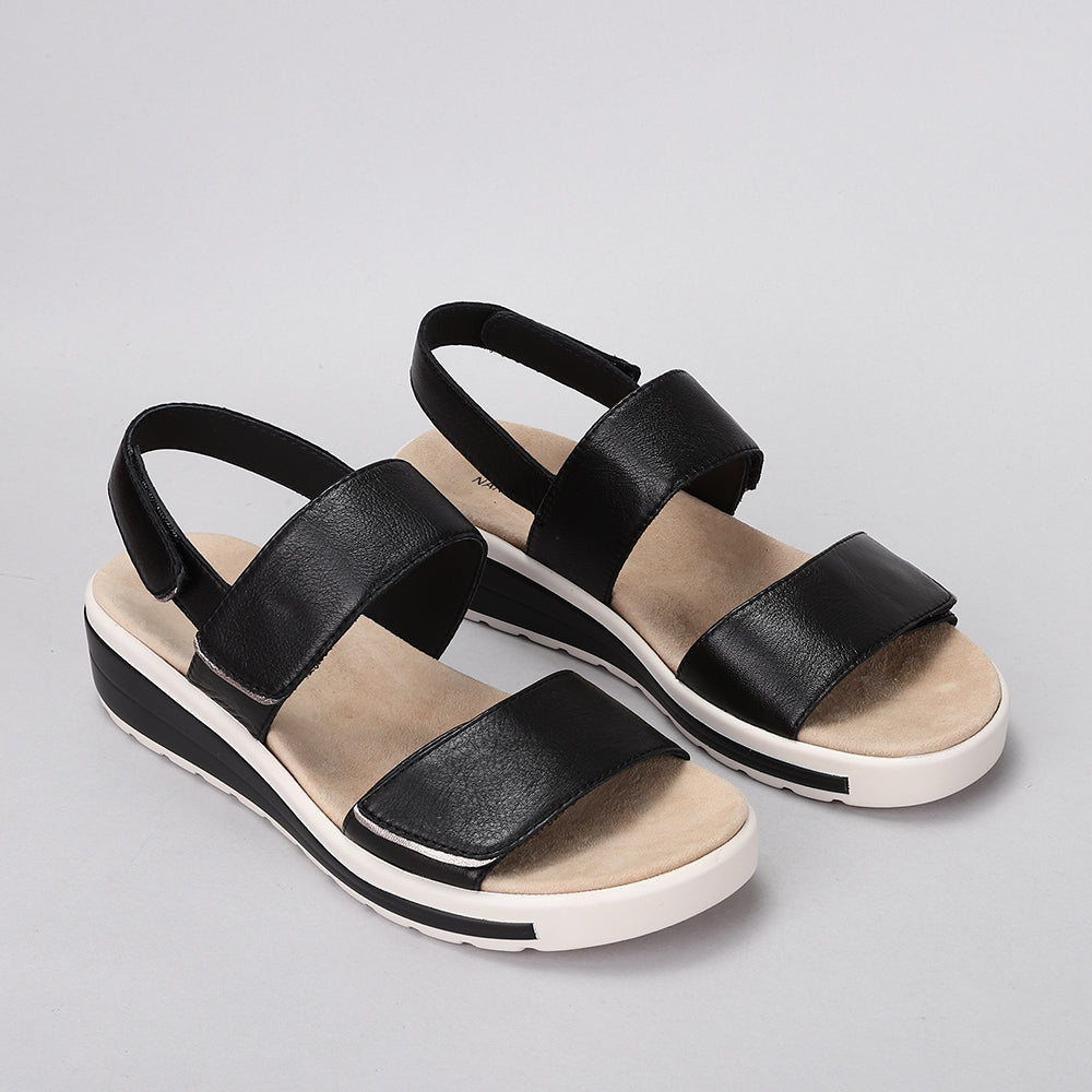 Naked Arches Hanza black sandals with open-toe design and adjustable straps, featuring cushioned footbed and stylish silhouette.
