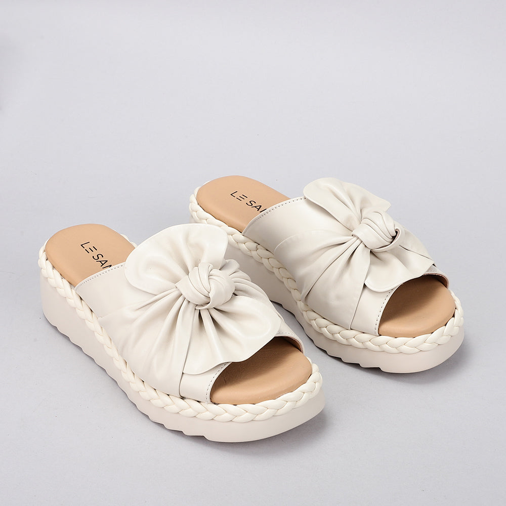 Le Sansa Eudore slip-on shoes in neutral fabric with a rounded toe and casual design, perfect for everyday wear.