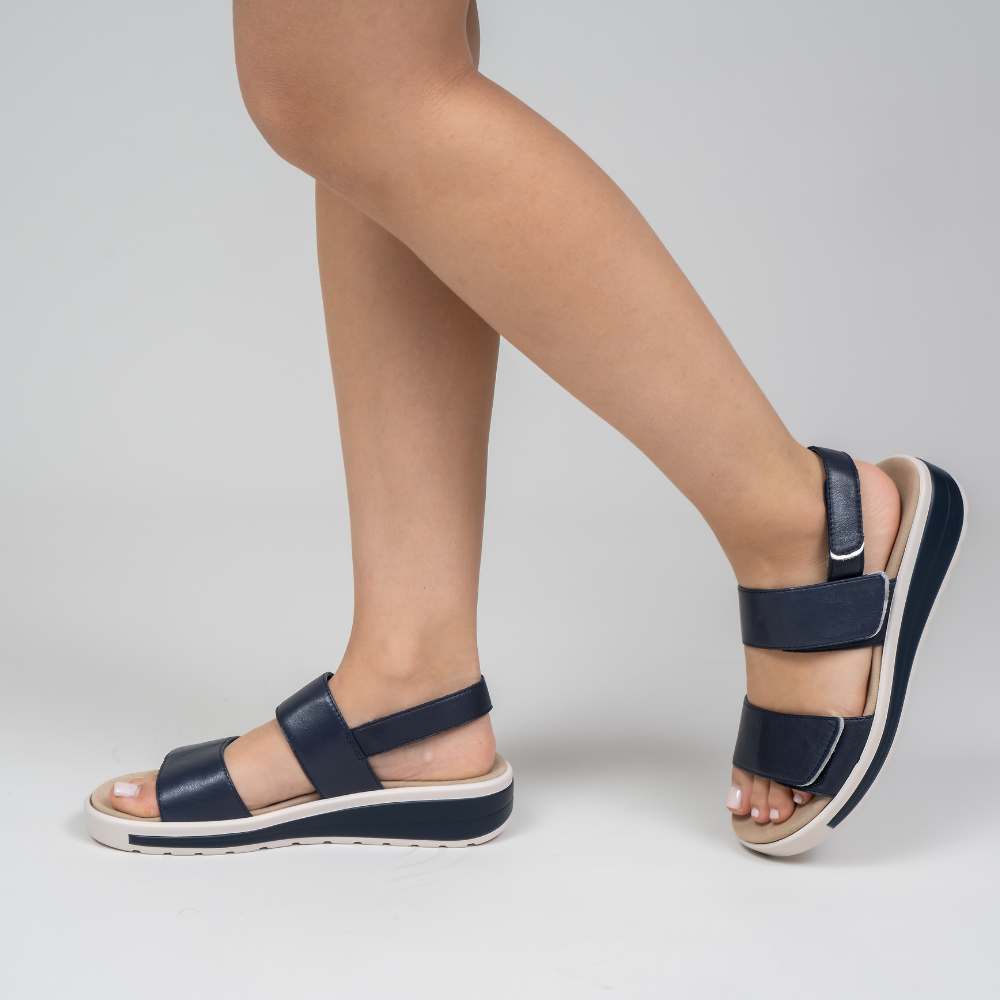 Naked Arches Hanza Navy sandals with navy straps and cushioned footbed, viewed from the side.