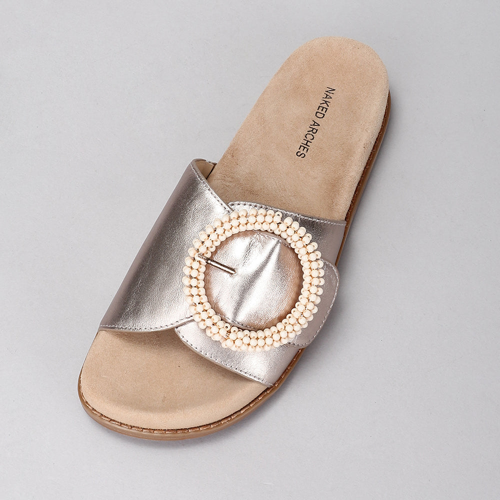 NAKED ARCHES ZOYA champagne slip-ons with sleek design and smooth texture, perfect for casual or dressy occasions.