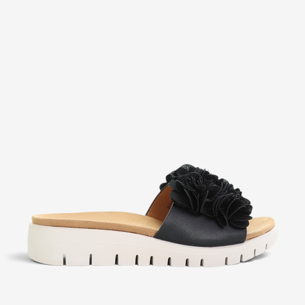 Black CC Resorts Domo slip-on shoes with a sleek design, featuring a comfortable fit and casual style.