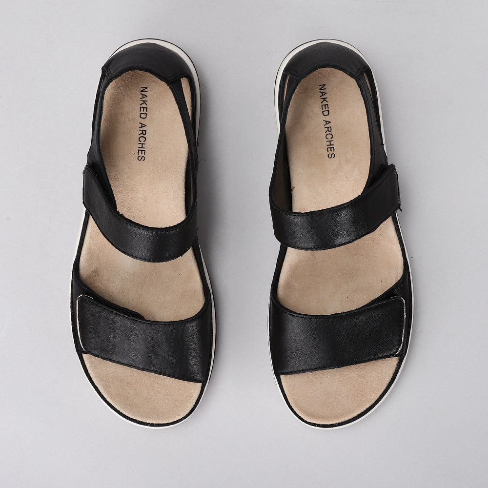 Naked Arches Happy Black sandals featuring black straps and cushioned footbed, designed for comfort and casual wear.