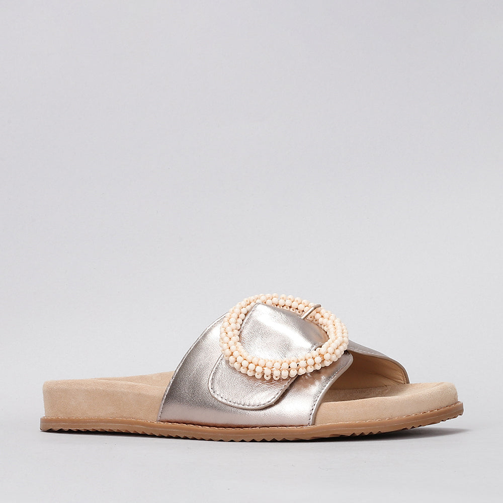 NAKED ARCHES ZOYA champagne slip-on shoes with sleek design and smooth finish, displayed on a plain background.