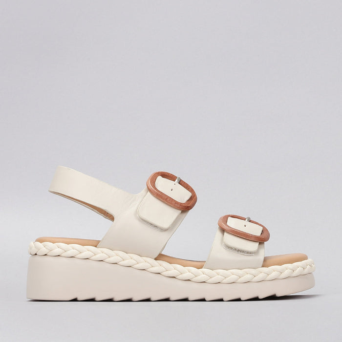 Le Sansa Sansa Emery Bone sandals with strappy design and flat sole, showcasing neutral-toned leather straps and open toe style.
