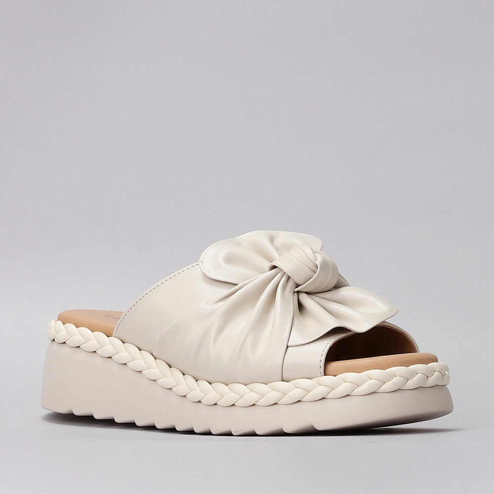 Le Sansa Eudore cream slip-ons with beige fabric and white soles, featuring a comfortable, casual design.