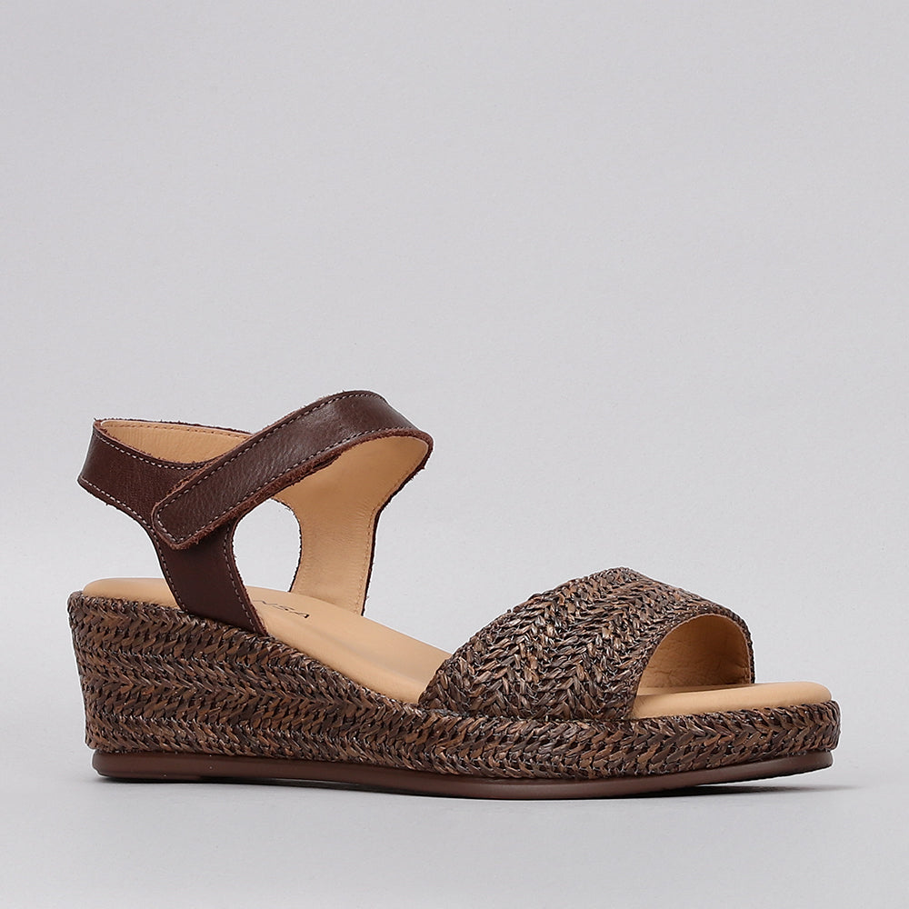 Le Sansa Pilia Chocolate sandals with a sleek design, featuring chocolate-colored straps and comfortable flat soles.