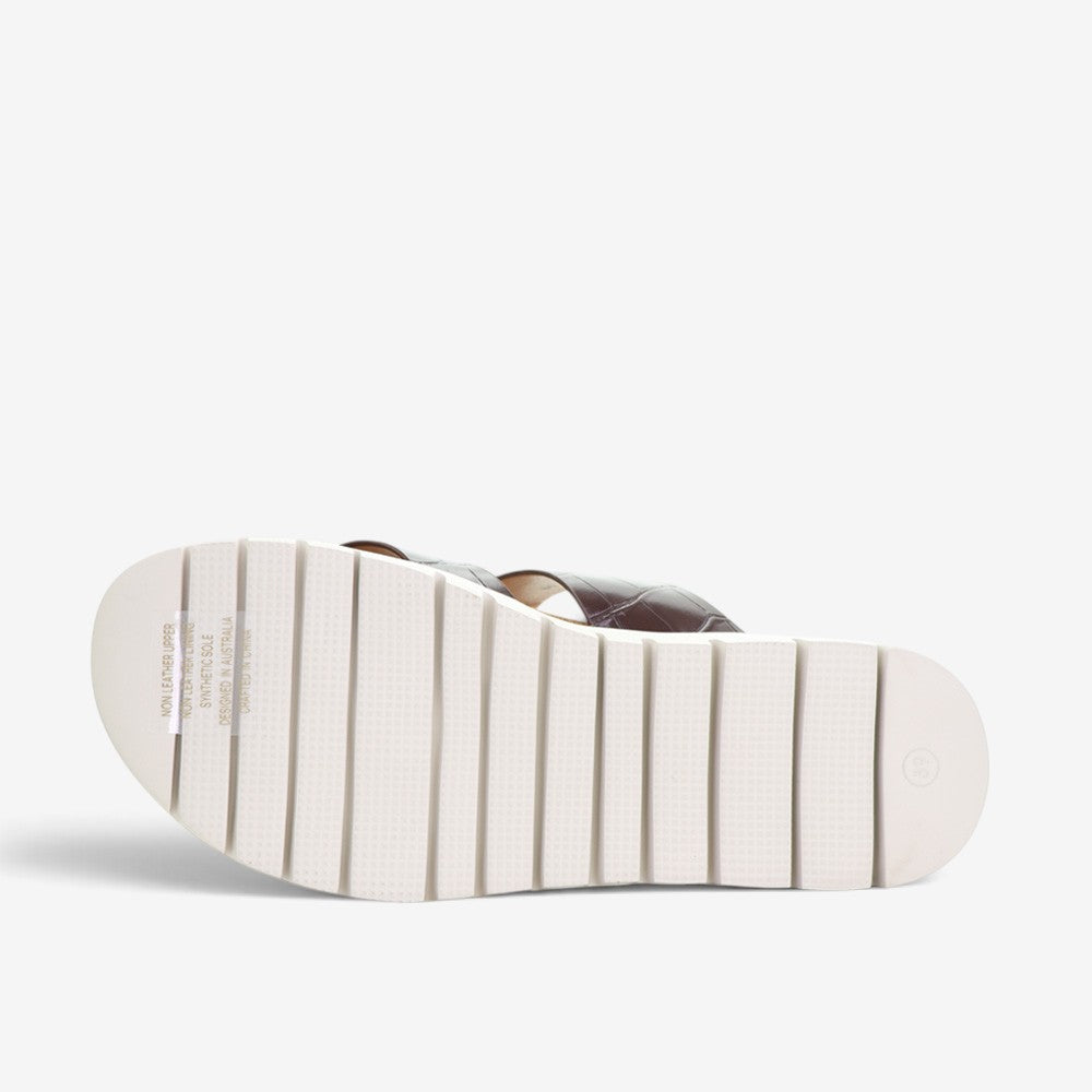 CC Resorts Domino Chocolate Crocs slip-ons with a playful pattern and comfortable design, perfect for casual wear.