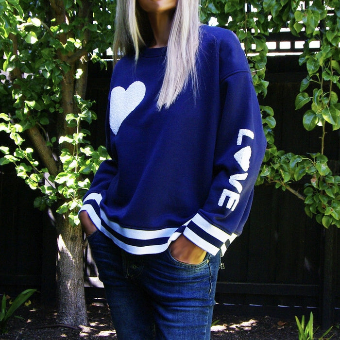 Navy Charlie Heart sweater by Who's Charlie featuring a cozy knit fabric and a heart design on the front.