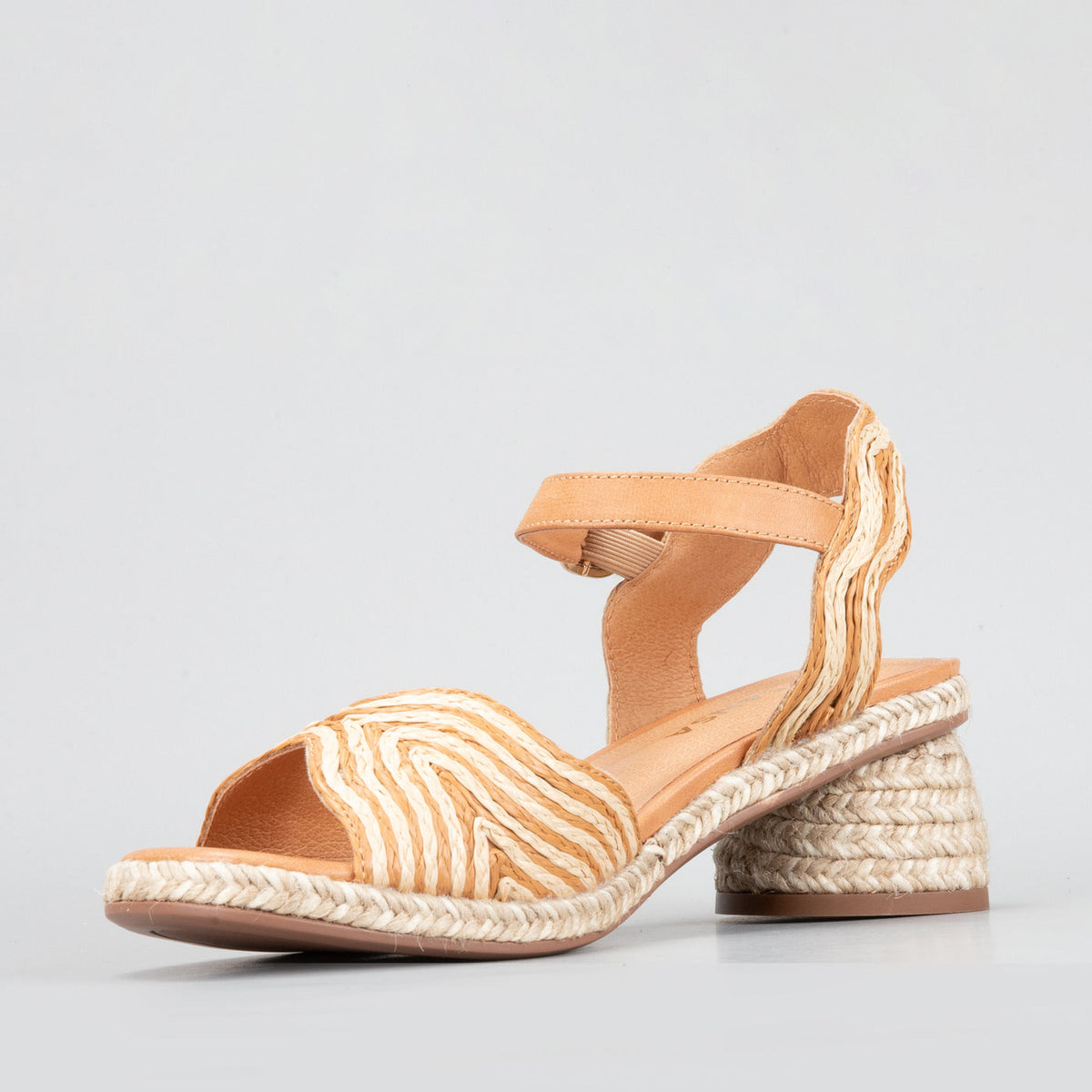 Le Sansa Alys tan and beige sandals with open toe design and ankle straps, displayed on a neutral background.