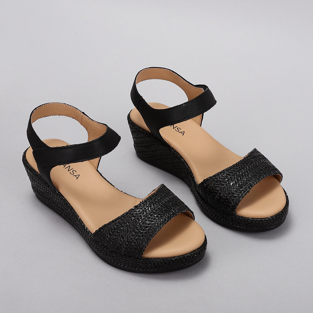 Le Sansa Pilia Black sandals featuring sleek black straps and a comfortable flat sole, perfect for casual summer wear.