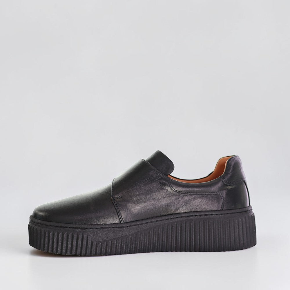 Le Sansa Philia black sneakers with sleek design and white sole, showcasing the stylish footwear from the side view.