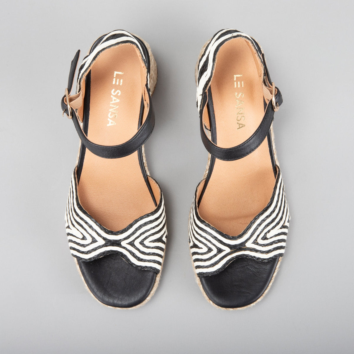 Le Sansa Alys black and white sandals with open toes and strap design, perfect for casual summer wear.