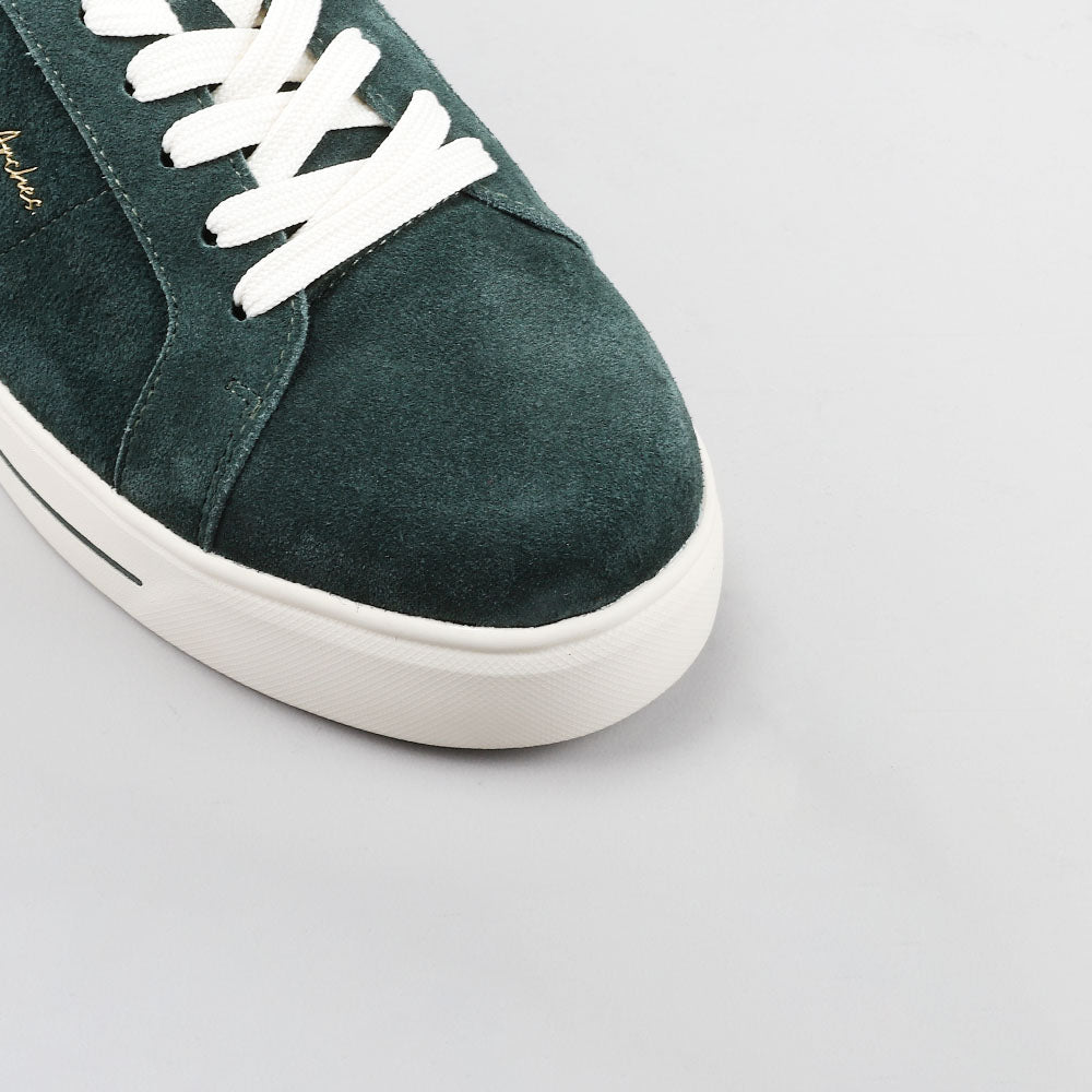 Close-up of NAKED ARCHES Azealia DK Green sneakers showing their sleek design and green leather material.