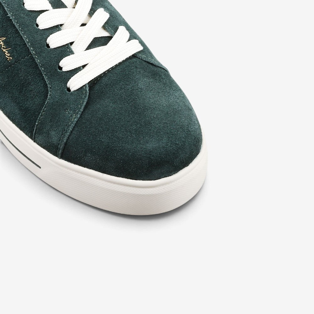 Close-up of NAKED ARCHES Azealia DK Green sneakers showing the green suede material and stylish design details.