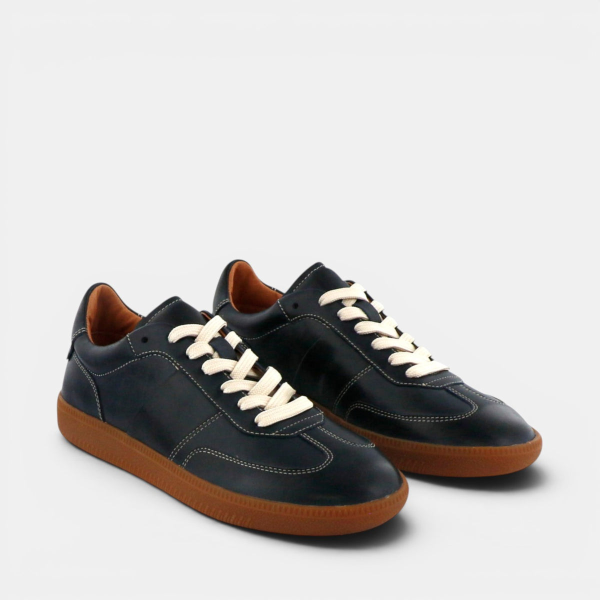 Eos Antigo navy sneakers with white soles and laces, featuring a sleek low-top design and stylish navy blue color.