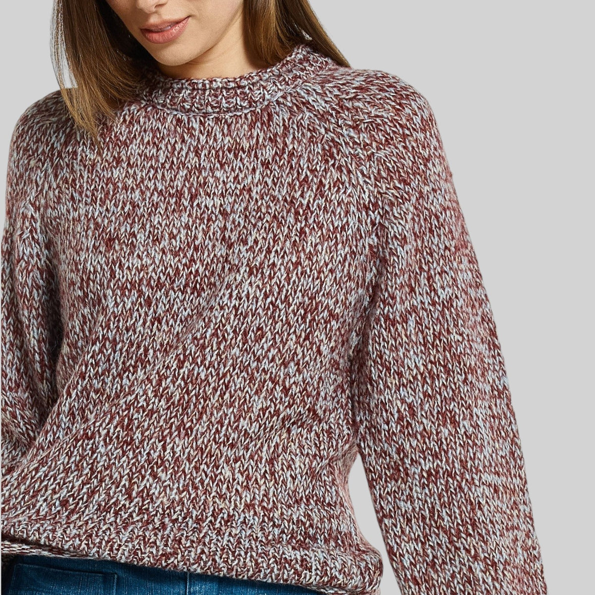 Betty Basics Gracie multi red sweater displayed on a hanger, showcasing its soft knit fabric and stylish design.