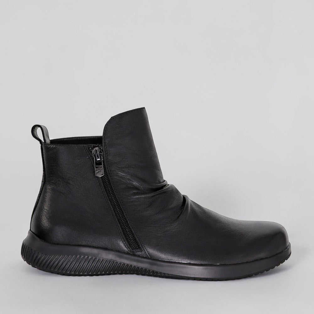 Black NAKED ARCHES Yila boots with sleek design and pointed toes, featuring a tall stiletto heel and smooth leather finish.