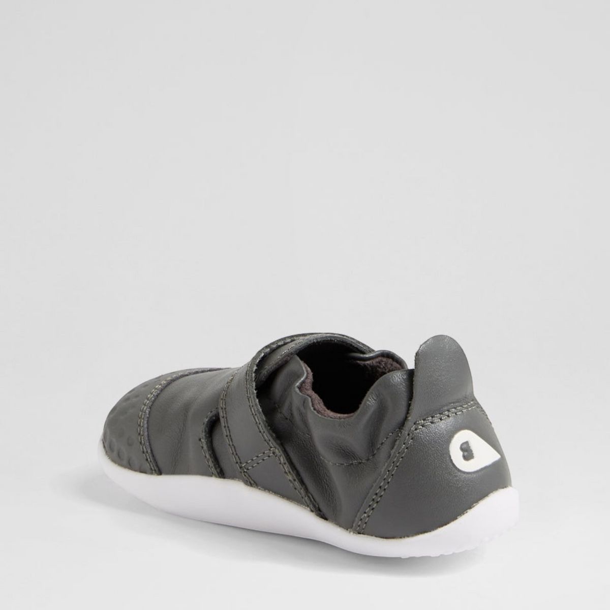 Baby sneakers by Bobux, XP GO Smoke style, featuring soft gray fabric with white sole and breathable design for comfortable little feet.