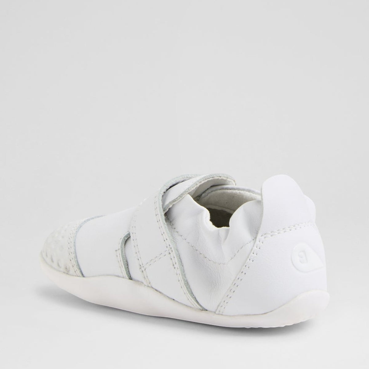 Baby white sneakers by Bobux XP GO, featuring soft sole and breathable material for comfortable toddler footwear.