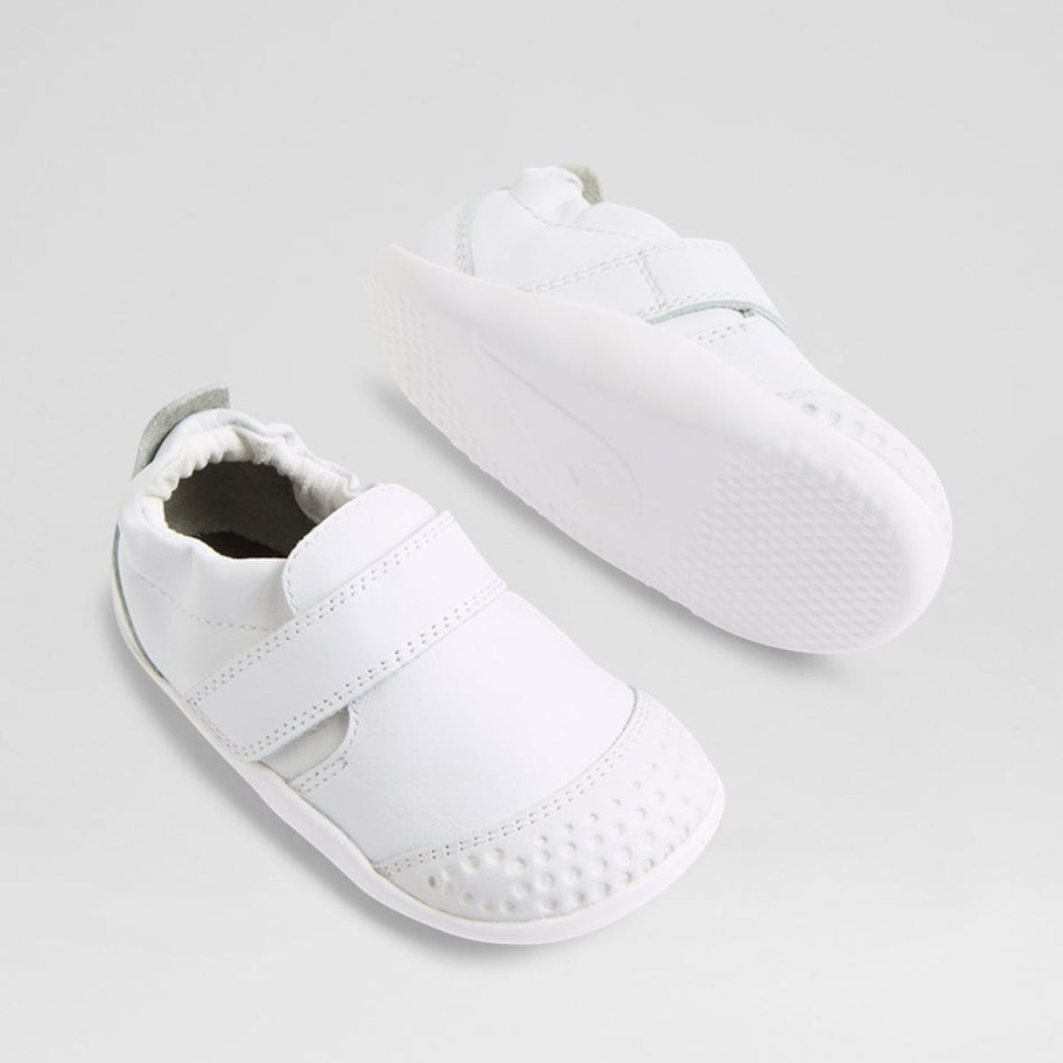Baby sneakers by Bobux, XP GO model in white, featuring soft fabric and flexible soles designed for early walkers.