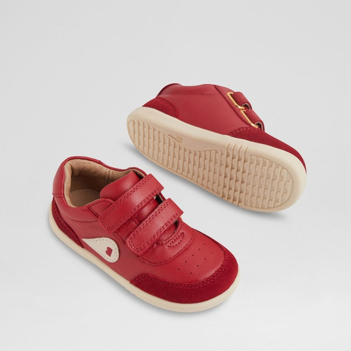 Baby Bobux Champ Chalk sneakers in Pompeian Red, shown in a close-up of the toddler shoes with velcro straps and soft soles.