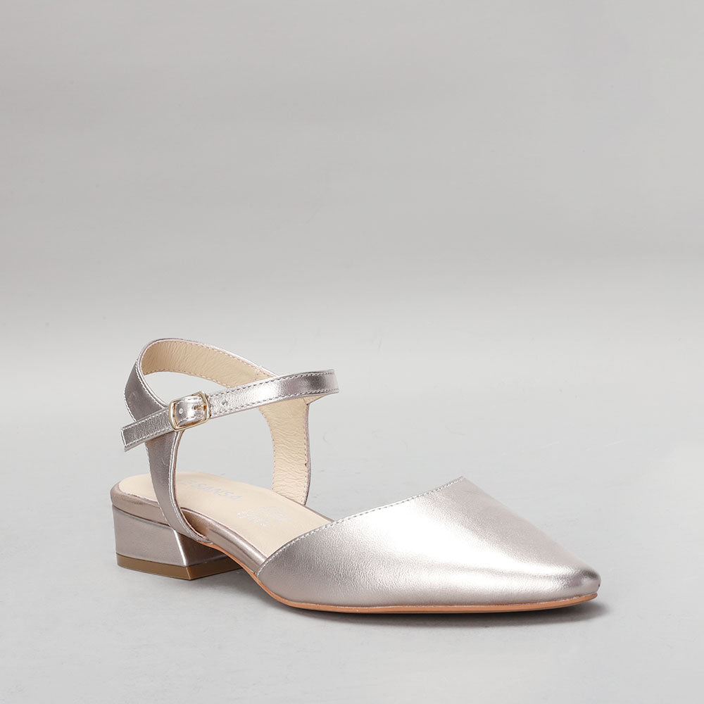 Le Sansa Coralie Champagne sandals with beige straps and low heel, displayed on a neutral background.