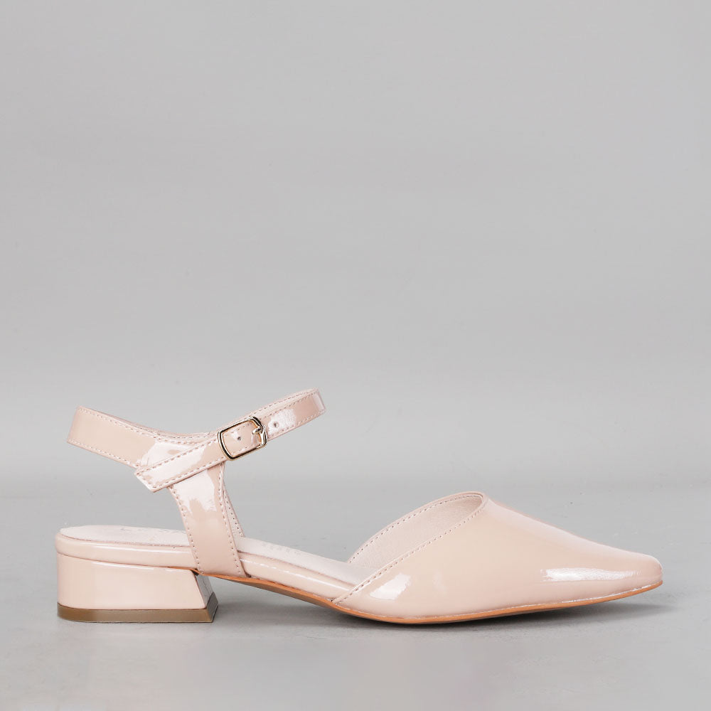 Le Sansa Coralie Nude Patent sandals displayed from the side showing sleek, shiny nude patent leather design.