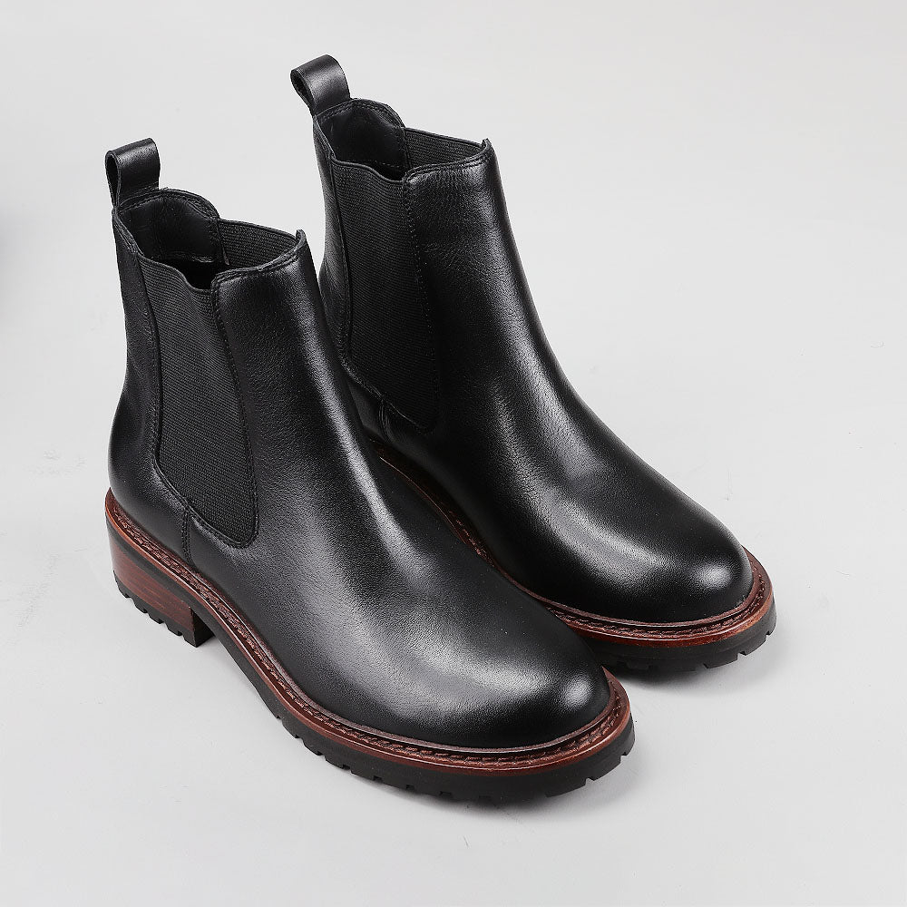 Pair of black Le Sansa Costa boots with sleek design and pointed toes, shown side view on a white background.