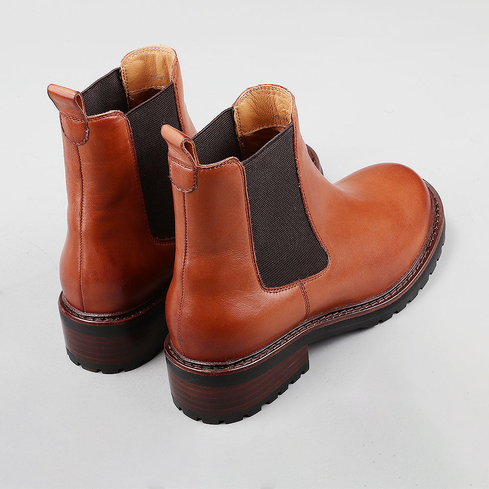 Pair of Le Sansa Costa Brandy boots showing the back view with stylish stitching and leather material.