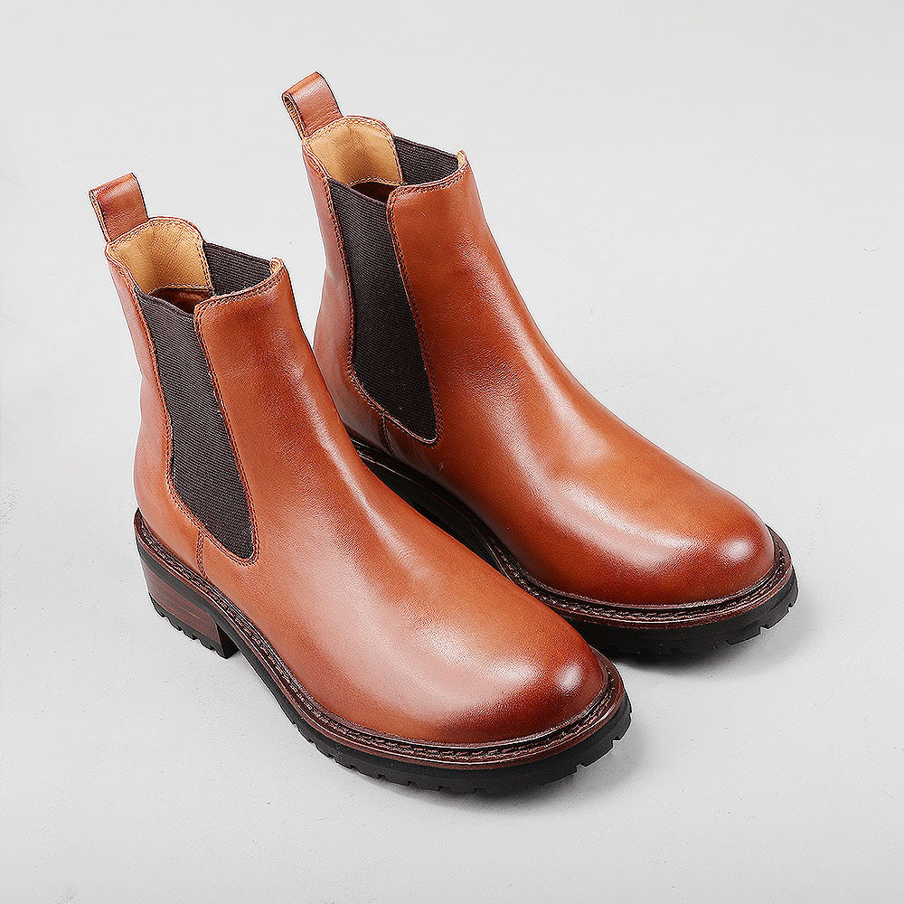 Pair of Le Sansa Costa Brandy boots with tan leather and stylish stitching, showcasing a trendy ankle boot design.