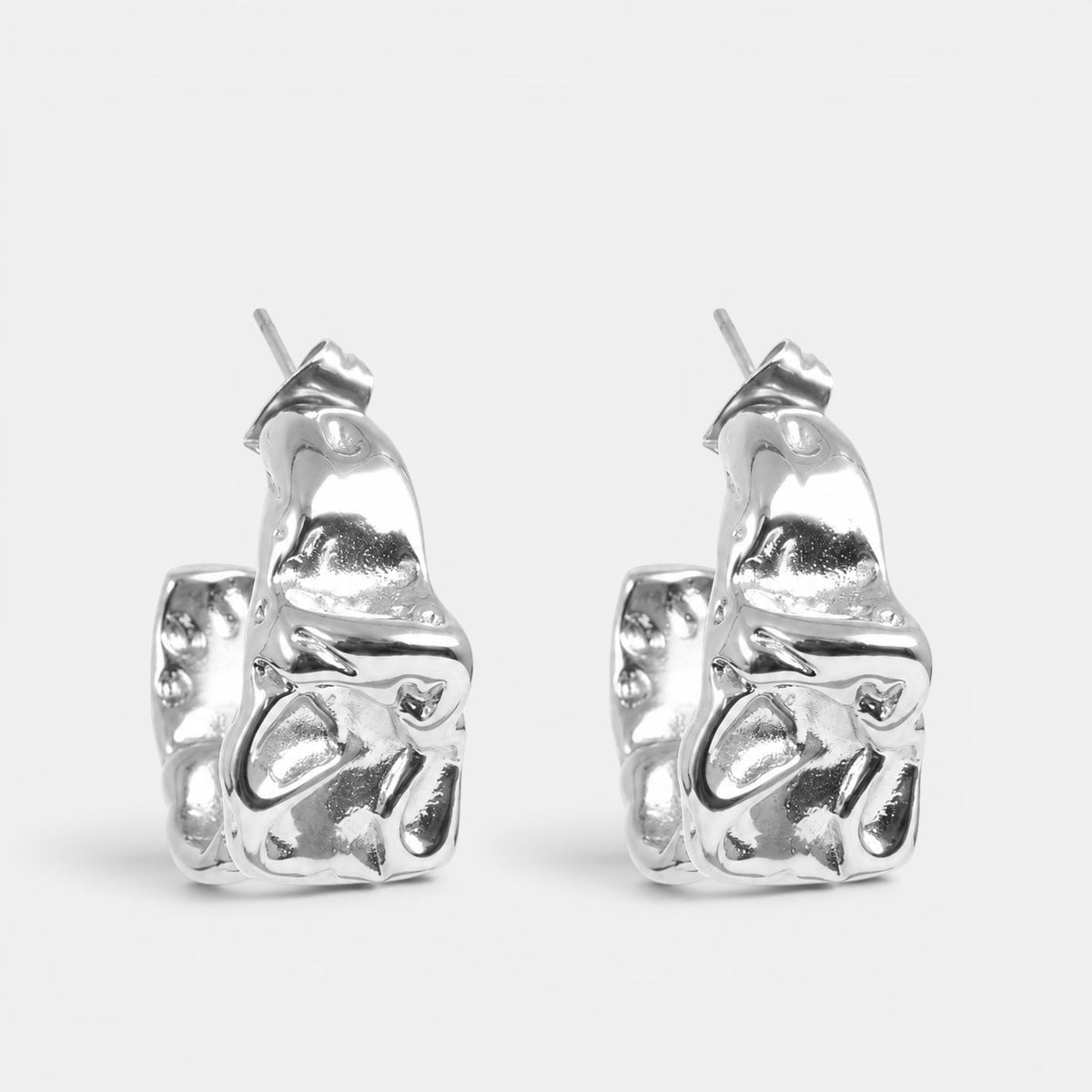 Silver Crickle earrings by A & C Oslo featuring intricate, textured design and classic hoop style.