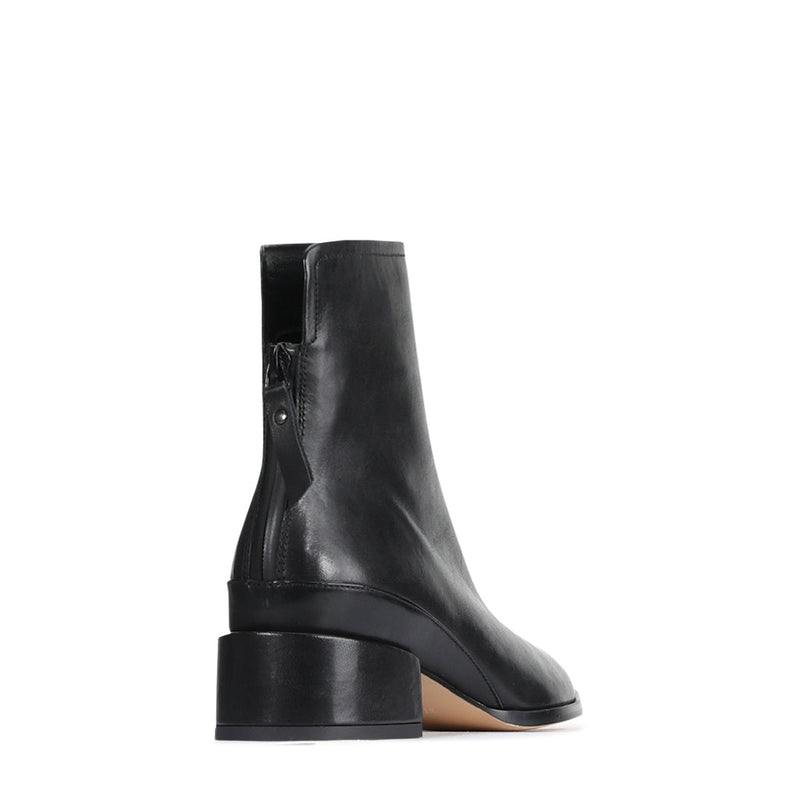 Eos Cast Black boots shown from the back angle, featuring sleek black leather design and stylish stitching details.