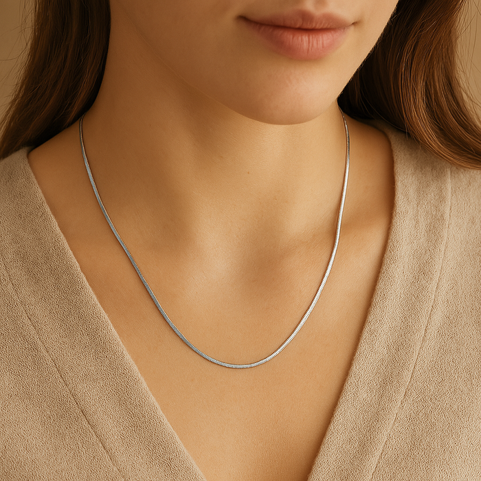A & C Oslo sleek snake chain necklace with a smooth, shiny silver finish, lying flat to showcase its elegant, flexible design.