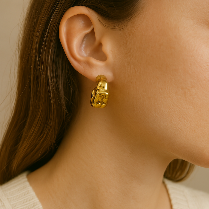 A pair of Crickle Gold Earrings by A & C Oslo featuring sleek, minimalist gold earring designs on a white background.